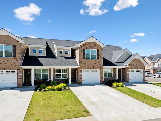 view of front of home featuring a front lawn, driveway, roof with shingles, a garage, and brick siding