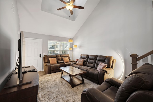 living area with high vaulted ceiling, ceiling fan, and wood finished floors