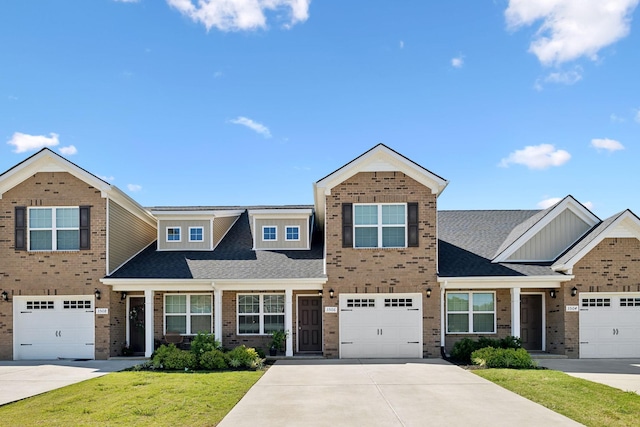 view of front facade with a front yard, a garage, brick siding, and driveway