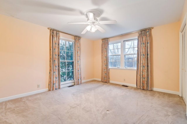 unfurnished room featuring visible vents, baseboards, carpet floors, and ceiling fan