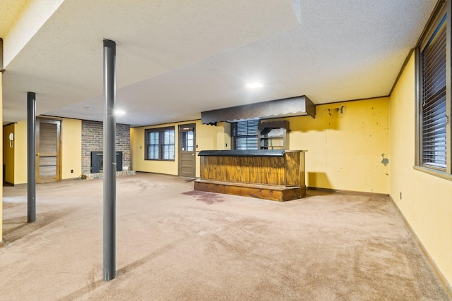 basement with baseboards, carpet, a bar, and a textured ceiling