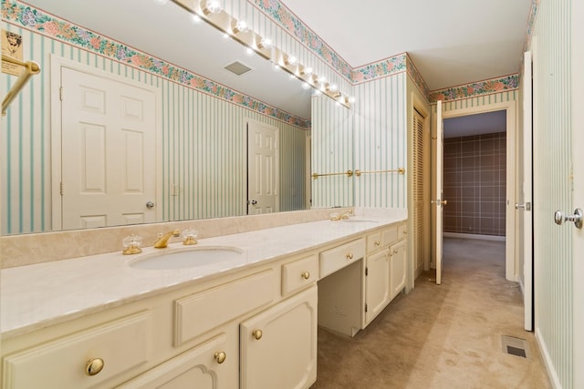 full bath featuring a sink, visible vents, double vanity, and wallpapered walls