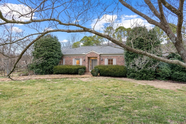 ranch-style house featuring a front yard, brick siding, and a shingled roof