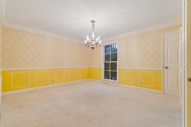 carpeted spare room with ornamental molding, wallpapered walls, an inviting chandelier, wainscoting, and a decorative wall