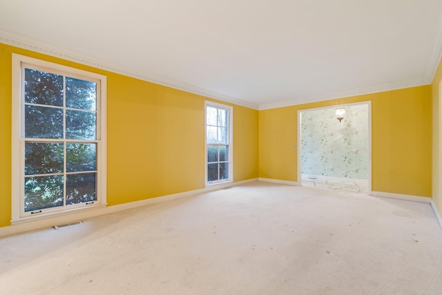 unfurnished room with carpet flooring, visible vents, baseboards, and ornamental molding