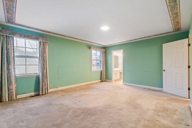 carpeted spare room with crown molding and baseboards