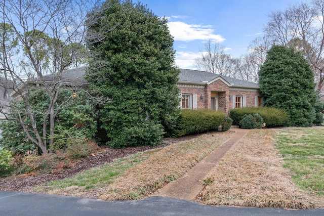 view of front of house with brick siding and a shingled roof