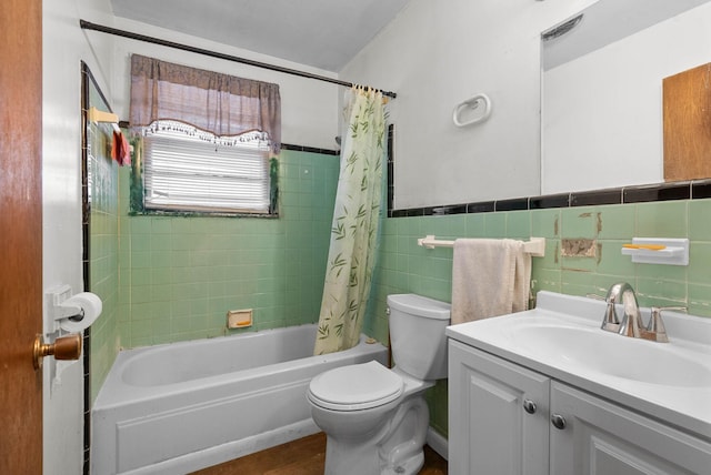 bathroom with a wainscoted wall, shower / tub combo with curtain, toilet, tile walls, and vanity