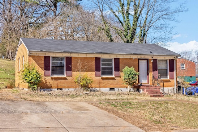 view of front of home featuring crawl space, brick siding, and a shingled roof