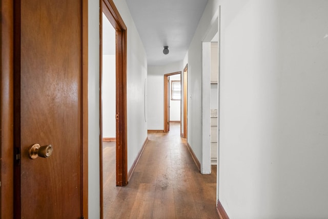 hallway featuring hardwood / wood-style floors and baseboards