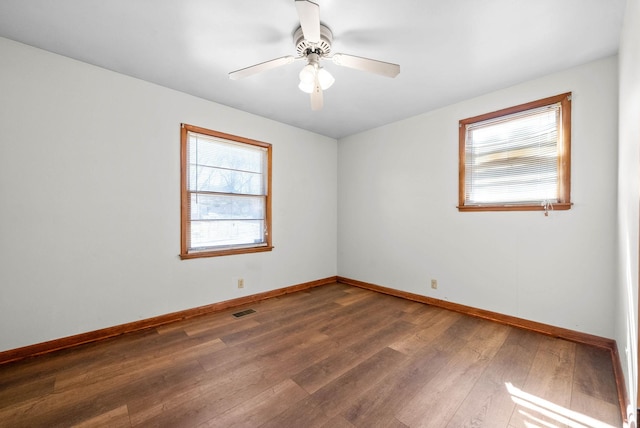 unfurnished room featuring visible vents, baseboards, a ceiling fan, and hardwood / wood-style floors