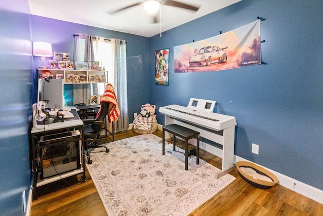 office space with a ceiling fan, wood finished floors, and baseboards