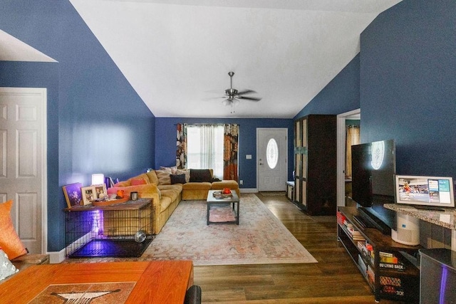 living area with vaulted ceiling, wood finished floors, baseboards, and ceiling fan