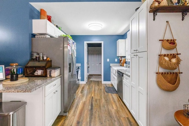 kitchen with white cabinets, dishwasher, baseboards, and wood finished floors