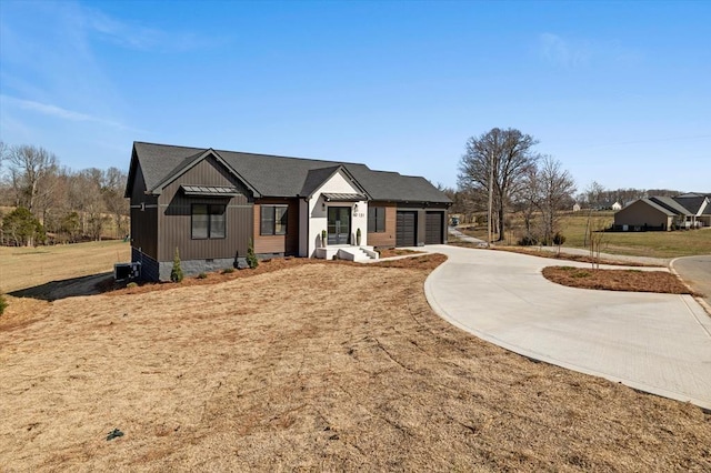 modern farmhouse featuring board and batten siding, a front lawn, concrete driveway, crawl space, and an attached garage