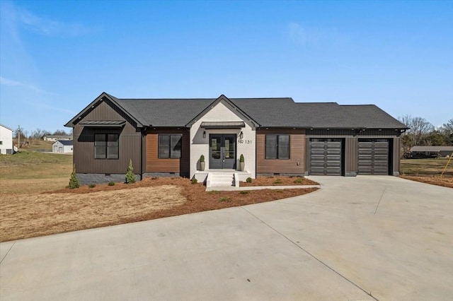 modern inspired farmhouse featuring concrete driveway, roof with shingles, french doors, crawl space, and an attached garage