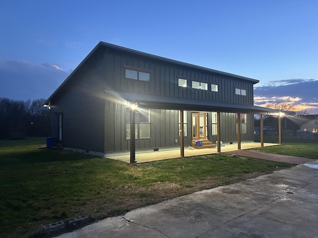 back of house featuring crawl space, a yard, and board and batten siding