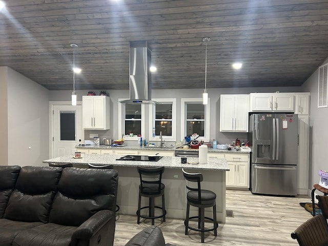 kitchen featuring a sink, stainless steel fridge, light wood-style floors, and white cabinetry