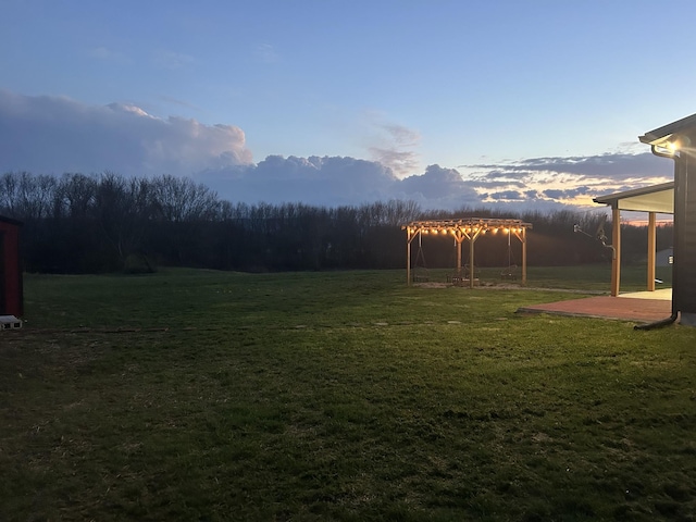 yard at dusk featuring a pergola