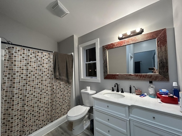 bathroom featuring visible vents, toilet, wood finished floors, lofted ceiling, and vanity