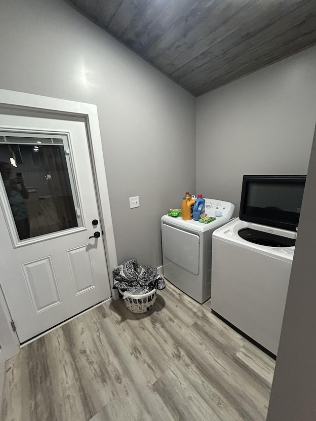 laundry room with laundry area, wood finished floors, and washer and clothes dryer