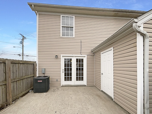 back of property featuring cooling unit, fence, french doors, and a patio area