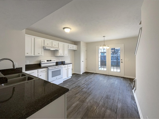 kitchen with dark countertops, under cabinet range hood, white cabinets, white electric stove, and a sink