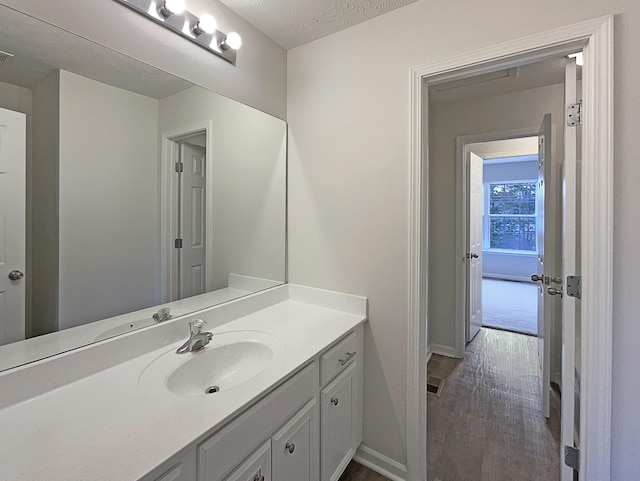 bathroom with vanity, baseboards, and wood finished floors