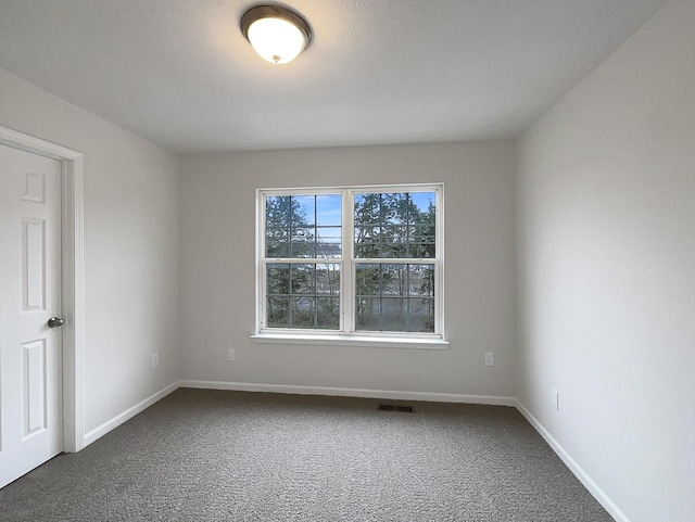 carpeted spare room with baseboards and visible vents