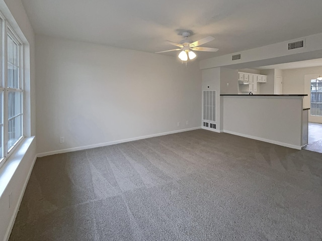 spare room with visible vents, baseboards, ceiling fan, and dark carpet