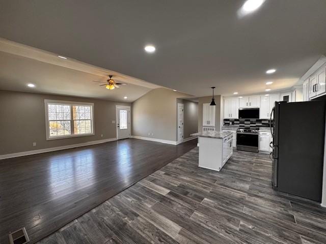 kitchen with a kitchen island, dark wood-type flooring, appliances with stainless steel finishes, white cabinetry, and open floor plan