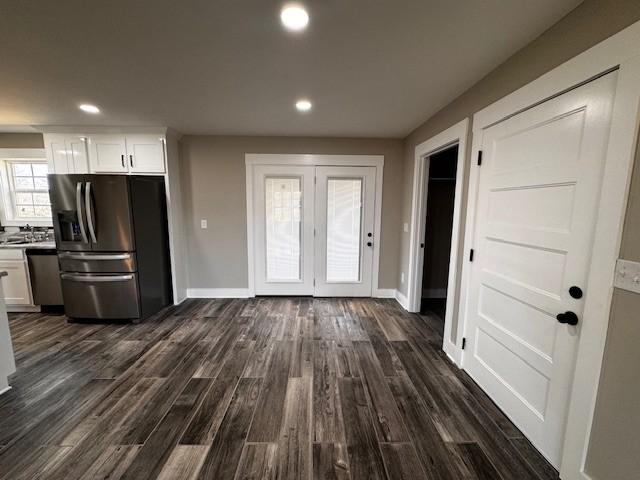 kitchen featuring baseboards, dark wood-type flooring, appliances with stainless steel finishes, and white cabinetry