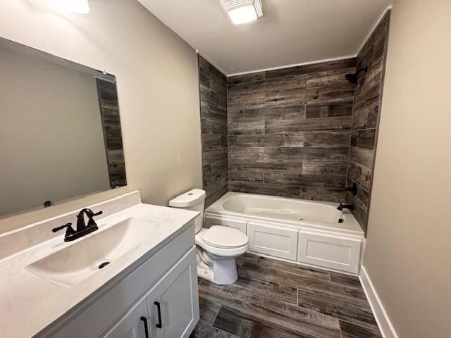 full bathroom with toilet, wood finished floors, baseboards, bathing tub / shower combination, and vanity