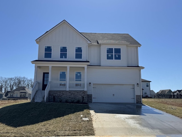 view of front of home featuring driveway, an attached garage, covered porch, board and batten siding, and brick siding