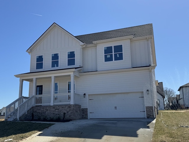 view of front of home featuring driveway, a porch, a garage, board and batten siding, and brick siding