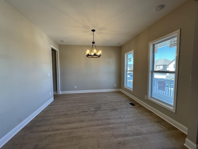 empty room with visible vents, baseboards, and dark wood-style floors