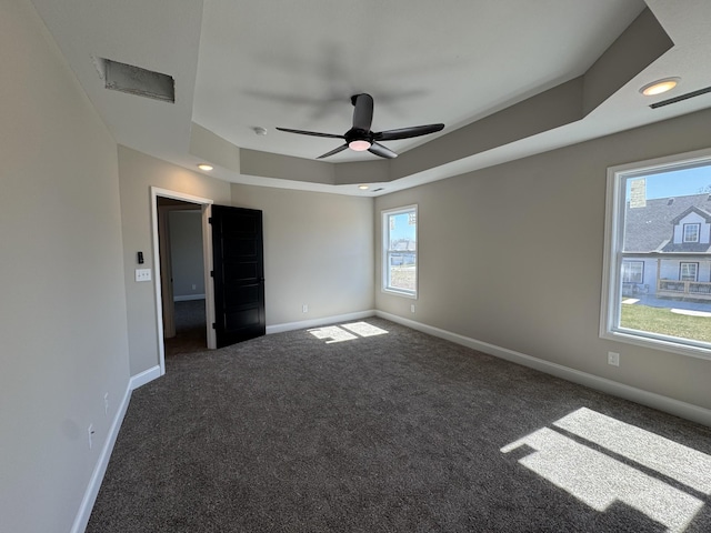 unfurnished bedroom with baseboards, a raised ceiling, carpet, and a ceiling fan