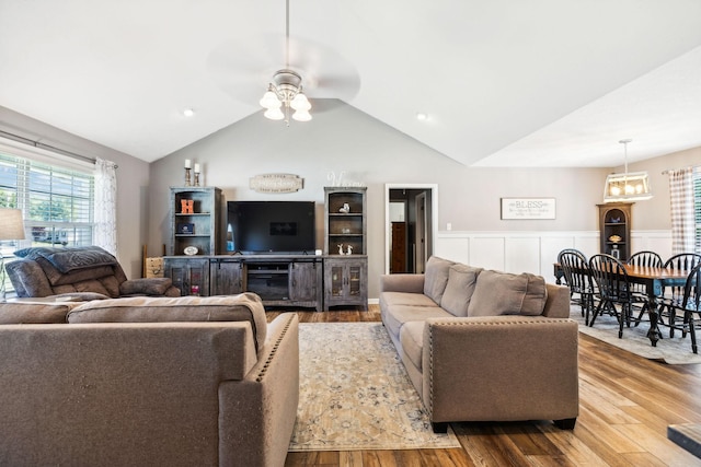 living room featuring wainscoting, a ceiling fan, lofted ceiling, and wood finished floors