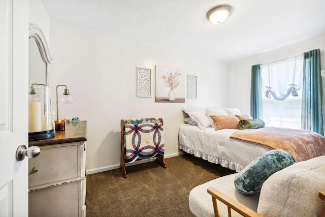 bedroom with dark carpet and baseboards