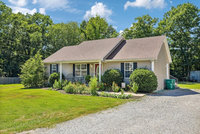 single story home featuring driveway, a front lawn, fence, covered porch, and a shingled roof