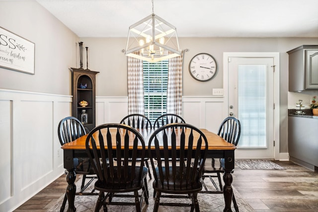 dining area featuring a chandelier, dark wood finished floors, and wainscoting