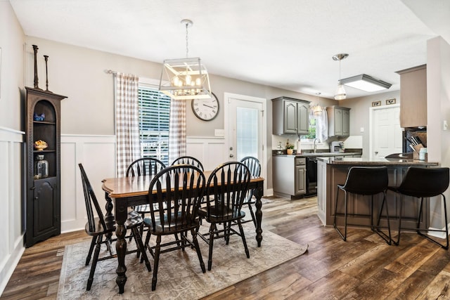 dining room with a decorative wall, dark wood-style floors, and wainscoting