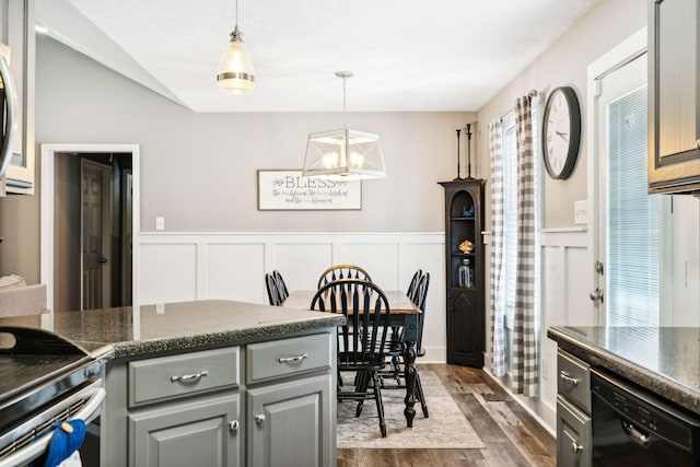 kitchen with dark countertops, gray cabinetry, dark wood-type flooring, decorative light fixtures, and dishwasher