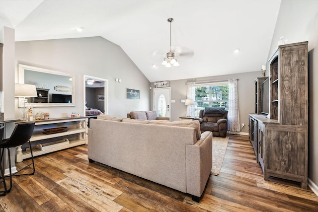 living room with baseboards, high vaulted ceiling, ceiling fan, and dark wood-style flooring