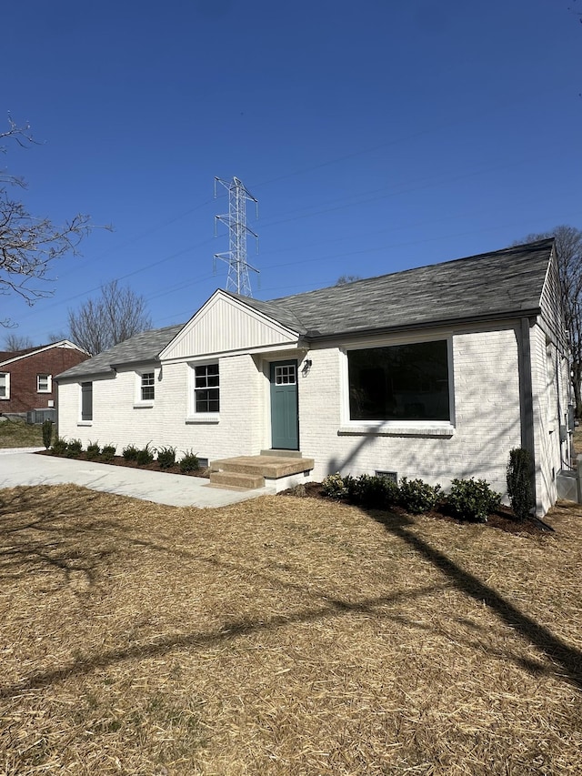 ranch-style house featuring brick siding and a shingled roof