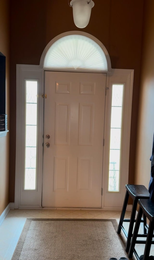 entryway with light tile patterned floors and baseboards