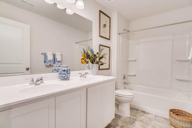 bathroom featuring double vanity, toilet, visible vents, and a sink