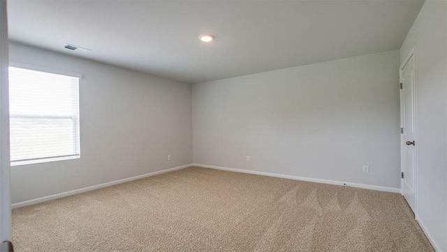 spare room featuring visible vents, baseboards, and carpet