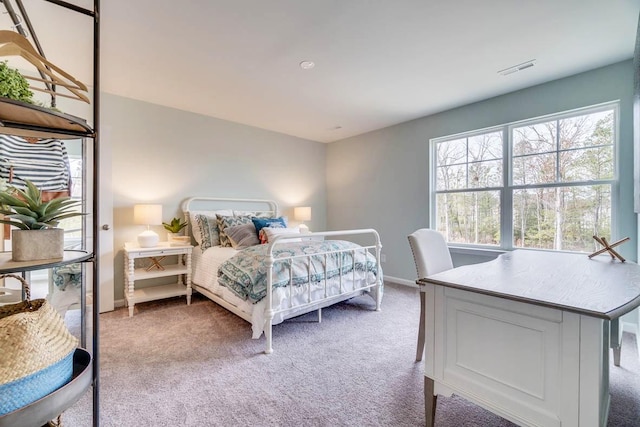 bedroom featuring baseboards, visible vents, and light carpet