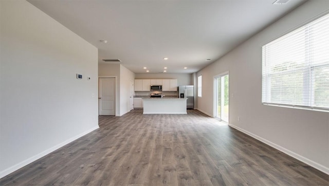 unfurnished living room with recessed lighting, visible vents, baseboards, and dark wood-style floors